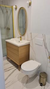 a bathroom with a toilet and a sink and a mirror at Apartamenty Rynek23 in Puck