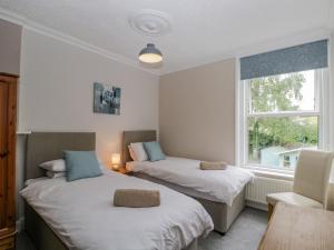 two beds in a room with a window at White Roses in Ross on Wye