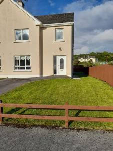 a house with a wooden fence in front of it at NO 9 The Willows, Ballinamore, Entire home in Ballinamore