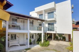 an exterior view of a white building with balconies at Apart Carolina in Florianópolis