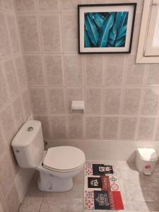 uma casa de banho com WC e uma fotografia na parede em Malaguetor Home Colón em Málaga