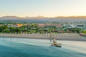 Akra Fethiye Tui Blue Sensatori - Ultra All Inclusive في فتحية: اطلالة على شاطئ به رصيف ومباني