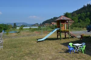 um parque infantil com um escorrega, uma mesa e cadeiras em Drinski dragulj em Višegrad