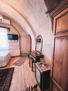 a room with a bed and a desk and a mirror at Local Cave House in Göreme