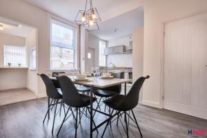 a kitchen and dining room with a table and chairs at Host Liverpool - Spacious Family Home by Aintree, Parking in Aintree