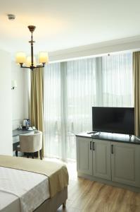 um quarto com uma cama e uma televisão de ecrã plano em FONTANA VERDE em Istambul