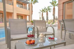 een dienblad met fruit op een tafel op een patio bij Anatoli Apartments in Agia Pelagia