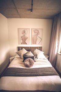a bedroom with a bed with three pictures on the wall at THE LOFT - Wiślana 28 in Piotrków Trybunalski