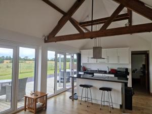 a kitchen with a counter and stools in a room at The Stables and Granary at Shawbroom Farm in Cheswardine