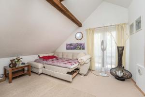 a attic bedroom with a bed and a table at Villa Suzana's Nature Hideout in Gospić +77 photos