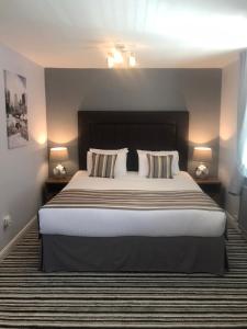 a bedroom with a large bed with two pillows at Aston Court Hotel in Derby