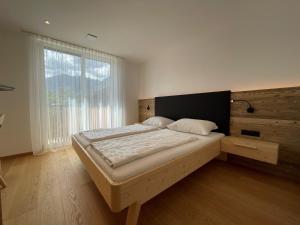 1 dormitorio con cama grande y ventana grande en Mesnerhof Chalet en Bressanone