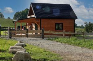 a small building with a fence and some rocks at Przystanek Śnieżka in Kowary