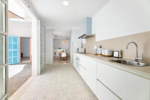 a kitchen with white cabinets and a sink at Albercutx Pollentia 1 in Port de Pollensa