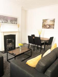 a living room with a couch and a table at Spacious 3 bedroom house can sleep 6 in Leeds