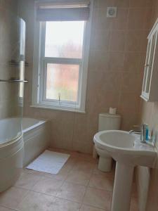 a bathroom with a tub and a toilet and a sink at Spacious 3 bedroom house can sleep 6 in Leeds