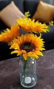 a vase filled with yellow sunflowers on a table at Spacious 3 bedroom house can sleep 6 in Leeds