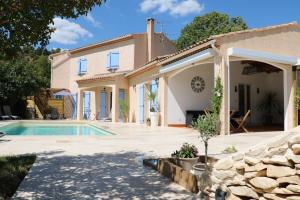 een villa met een zwembad en een huis bij La Villa des Moulins in Calvisson