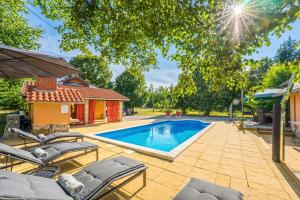 a swimming pool with lounge chairs next to a house at Villa Suzana's Nature Hideout in Gospić