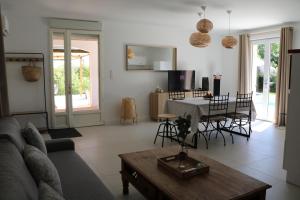 een woonkamer met een bank en een tafel bij La Villa des Moulins in Calvisson