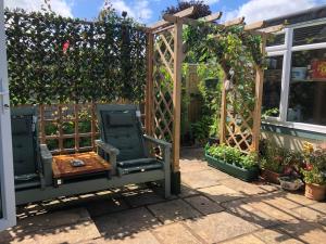a garden with a wooden pergola and a chair at Owly 'Ouse in Barnstaple