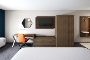 1 dormitorio con 1 cama, escritorio y TV en Holiday Inn Express & Suites Evansville Downtown, an IHG Hotel en Evansville