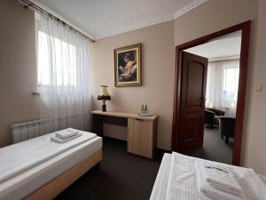 a hotel room with two beds and a mirror at Noclegi-Restauracja Boss in Mogilno