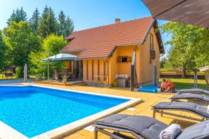 a swimming pool in front of a house at Villa Suzana's Nature Hideout in Gospić