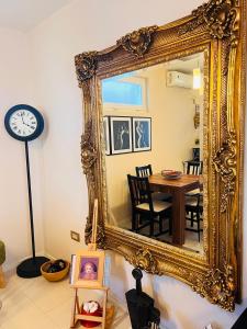 un gran espejo de oro en un comedor con mesa en Studio Apartment 21 en Danilovgrad