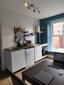 a kitchen with white appliances and a table in it at Apartment 2, Aberystwyth Town Centre in Aberystwyth