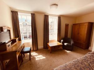 a bedroom with a bed and a desk and a chair at Cain Valley Hotel in Llanfyllin