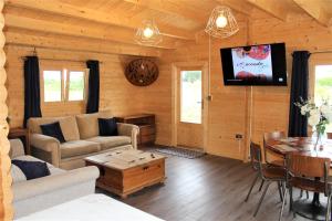 uma sala de estar com um sofá e uma televisão numa cabina em Stunning 5-Bed Cabin in Ashton Under Hill em Evesham
