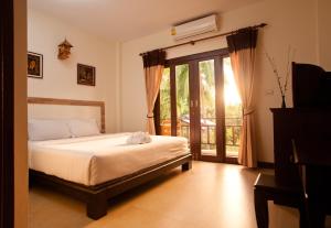 a bedroom with a bed and a sliding glass door at Shanti Boutique Hotel in Srithanu