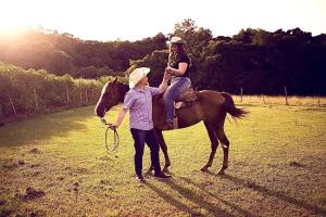 a woman standing next to a girl on a horse at Hospedagem Bela Roça - Lareira, Passeio a cavalo, ovelhas in Bom Princípio