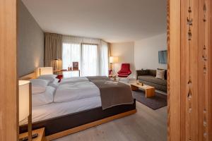 ein Schlafzimmer mit einem großen Bett und ein Wohnzimmer in der Unterkunft Hotel Schweizerhof Lenzerheide in Lenzerheide