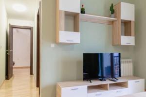 AirMi hotel في Surčin: غرفة معيشة مع تلفزيون بشاشة مسطحة على شاشة تلفزيون