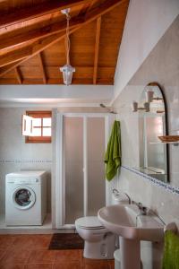 a bathroom with a toilet and a sink and a washing machine at CR las Nuevitas Tranquilidad y Descanso in Hermigua