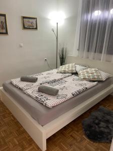 een bed met kussens in een slaapkamer bij Hiška Orel Terme Čatež in Čatež ob Savi