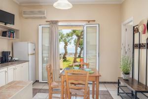 - une cuisine et une salle à manger avec une table et des chaises dans l'établissement Bella Vista Sea View Apartments, à Tragaki