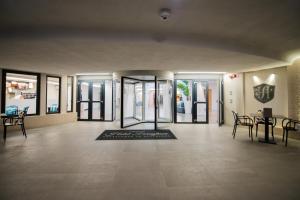 a lobby with glass doors and a rug on the floor at Grand Hotel Faraglioni in Acitrezza