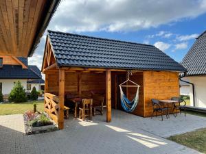 a large wooden cabin with a table and chairs at Vila Snezienka in Stará Lesná