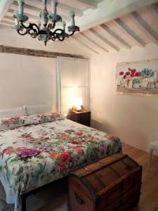 1 dormitorio con cama y lámpara de araña en Il giardino dei sogni, en Montefortino