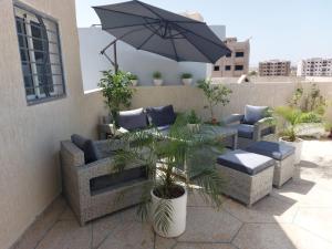 a patio with couches and an umbrella and plants at ZR Comfort Delux in Fez