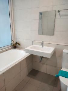 怡保的住宿－八角形怡保公寓，一间带水槽、浴缸和卫生间的浴室
