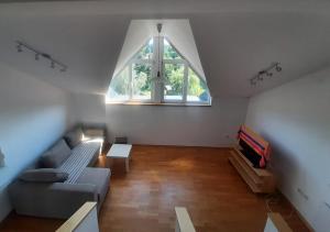 een woonkamer met een bank en een raam bij Riverside Vacation House Mrežnica in Donji Zvečaj
