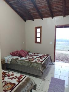 two beds in a bedroom with a view of the ocean at Pousada Taiani in Itaara