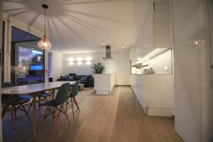 Il comprend une cuisine et un salon avec une table et des chaises. dans l'établissement Kirchberg Apartment - High End 2 Bedrooms in Luxembourg City, à Luxembourg