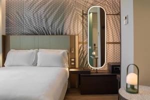 um quarto de hotel com uma cama e um espelho em Boutique Hotel Martini 17 em Milão