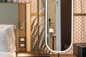 1 dormitorio con espejo junto a la cama en Boutique Hotel Martini 17, en Milán