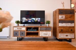 a living room with a tv on a wooden dresser at Urban Bliss - Contemporary Elegance in Modern Living Spaces in Voluntari